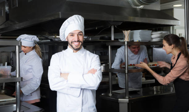 istock cheerful chef in kitchen with staff 1172562550