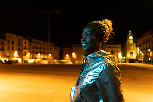 Cool young woman in Vic's Plaça Major at night