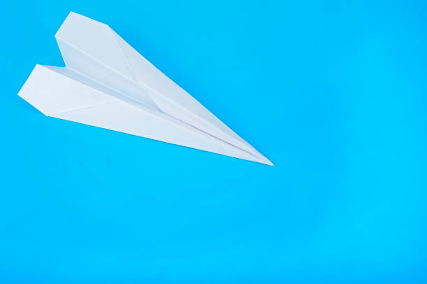 istock White paper airplane on a blue background. Travel plane concept. 1172565406