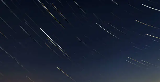 A photograph of a startrails in the sky under the starry sky