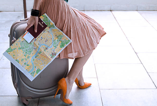 beautiful slim woman student sitting on luggage suitcase, holding passport and map for traveling.copy space - shoe leaving women summer imagens e fotografias de stock