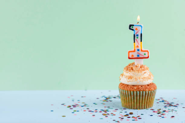 istock Delicious cupcake on a light green background with one candle and sparkles. 1172579122