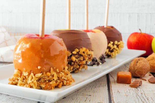 istock Fall candy apples with caramel, chocolate and nuts, close up on a plate against white wood 1172583416