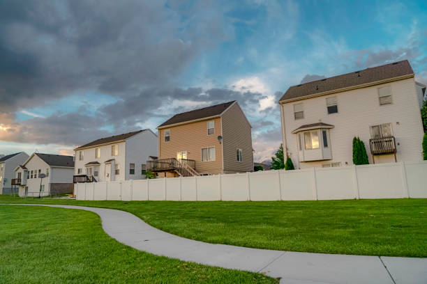 istock Facade of homes pathway and grass covered terrain under sky with gray clouds 1172583667