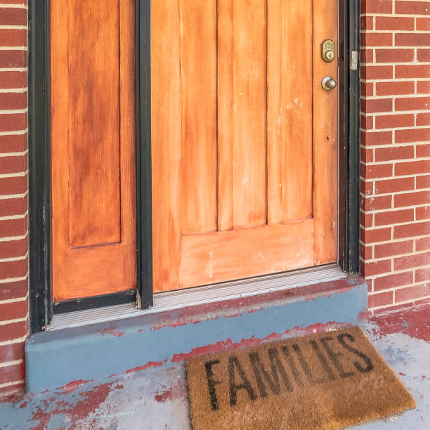 istock Square frame Home with brick and wood wall sections and glass paned front door and sidelight 1172583748