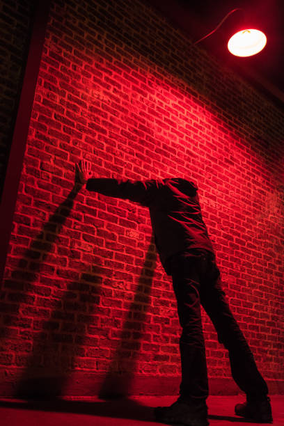 istock Young man leaning against the wall under a strong red light 1172584556