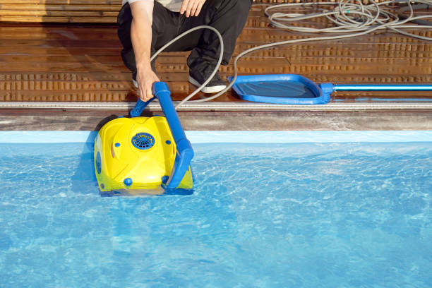 istock Hotel staff worker cleaning the pool. Automatic pool cleaners. 1172587209