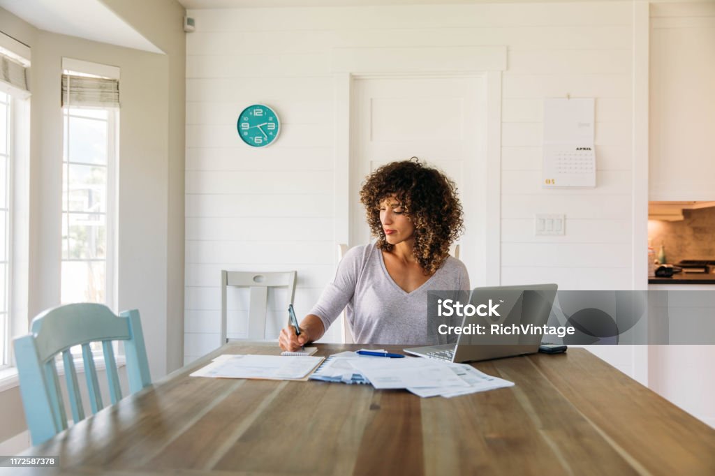 Donna che fa le finanze a casa - Foto stock royalty-free di Finanza
