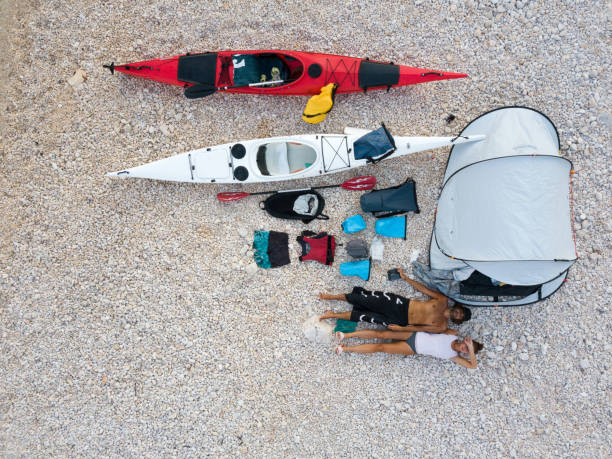 couples avec des kayaks sur la plage - canoeing people traveling camping couple photos et images de collection
