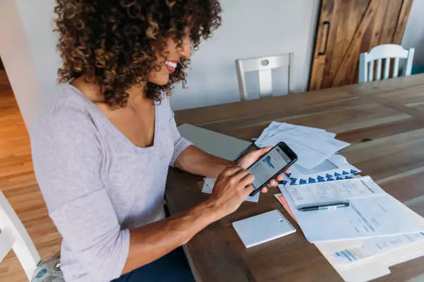 Photo of Woman Doing Finances at Home on Smart Phone