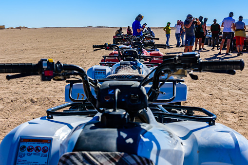 Hurghada, Egypt - December 10, 2018: Unrecognizable people near quad bikes during safari trip in Arabian desert not far from Hurghada city, Egypt