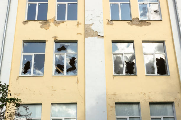 istock The glass of broken windows reflects the sky, a house with broken windows close up. 1172592802