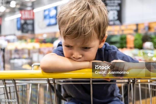 Nahaufnahme Frustriert Kind Junge Schaut Weg Sitzend In Einem Einkaufswagen Stockfoto und mehr Bilder von Kind