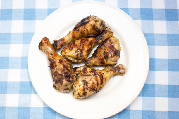 Barbecue Chicken Drumsticks on Plate on Checked Tablecloth, Overhead