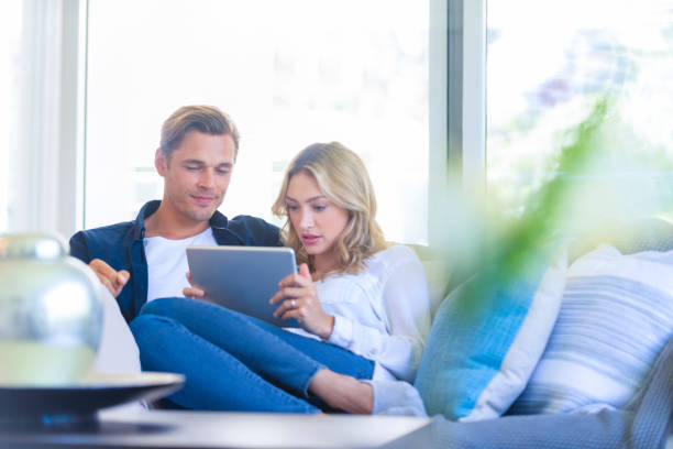 istock Worried couple looking at a digital tablet on the sofa. 1172601046