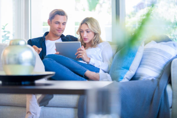 istock Worried couple looking at a digital tablet on the sofa. 1172601058