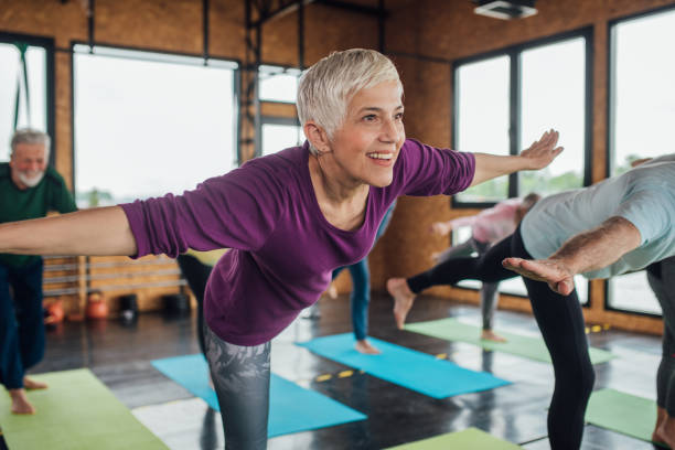 groupe de personnes âgées exerçant le yoga - tai chi photos et images de collection