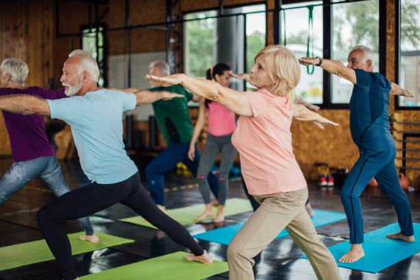 istock Group of seniors practicing yoga together 1172601206