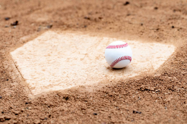 Home Plate Baseball Baseball laying on a worn home plate or base home run photos stock pictures, royalty-free photos & images