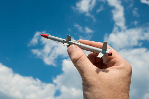 istock A man's hand fires a missile with a warhead into the sky. 1172609067