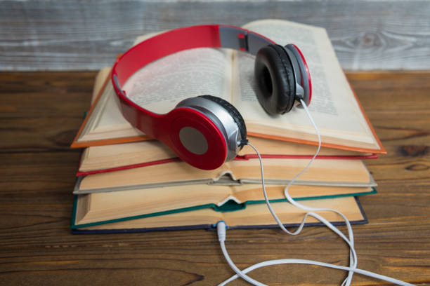 istock Red headphones on a stack of open books. 1172609087