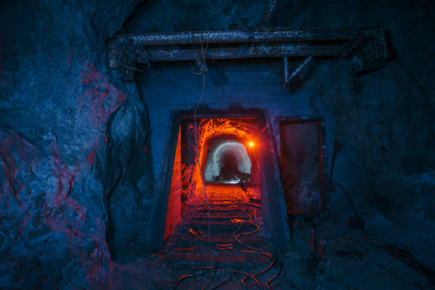 Dark dirty abandoned uranium mine with rusty remnants of railway