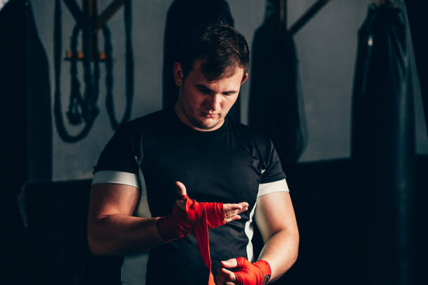 istock Strong boxer putting on red straps and getting ready to fight 1172616250