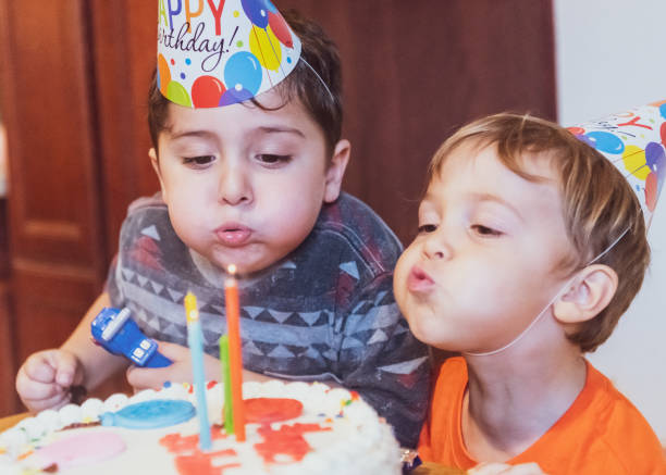 七十年代からのヴィンテージ画像、誕生日ケーキキャンドルを吹く子供たち - cake birthday domestic kitchen child ストックフォトと画像