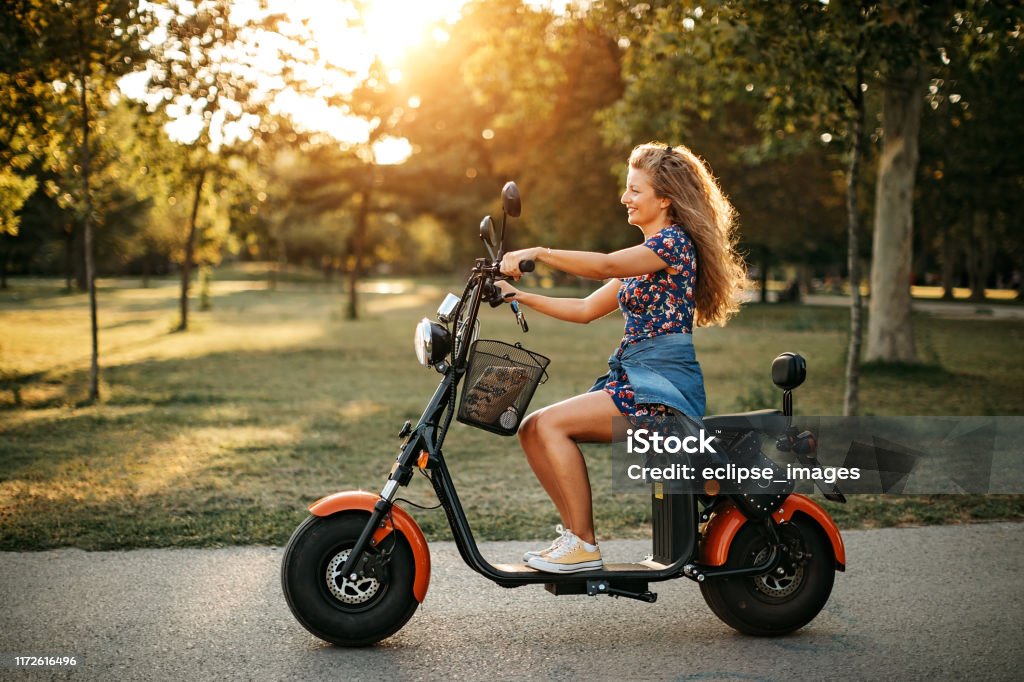 I love clean energy Woman using electric vehicle to drive in nature Electricity Stock Photo