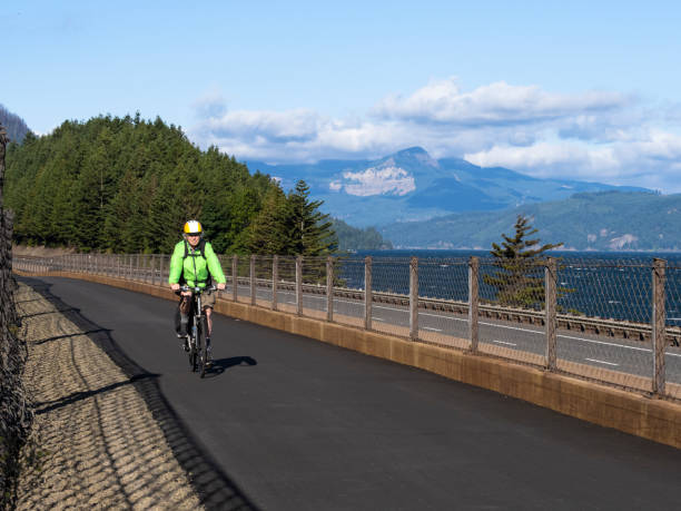 Senior Man Bike Rider Historic Columbia River Highway State Trail A senior man bicycling on the Historic Columbia River Highway State Trail. The new section of the trail opened in 2019 and can be accessed from I-84 or the historic US 30. This area offers spectacular views of the Columbia River with Oregon and Washington State scenery. This is part of the Columbia River Gorge. Not far from the Wyeth Trailhead. oregon us state photos stock pictures, royalty-free photos & images