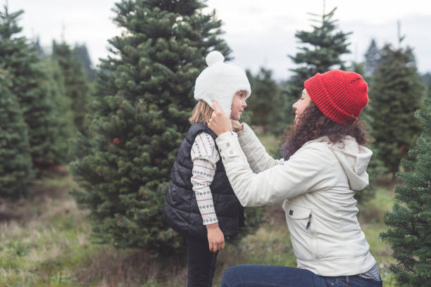 istock Mom adjusts her daughter's hat at a Christmas tree farm 1172619535