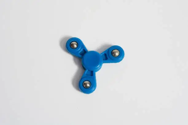 Photo of Fidget spinner on isolated background. Fashion toy to calm anxiety and lack of attention