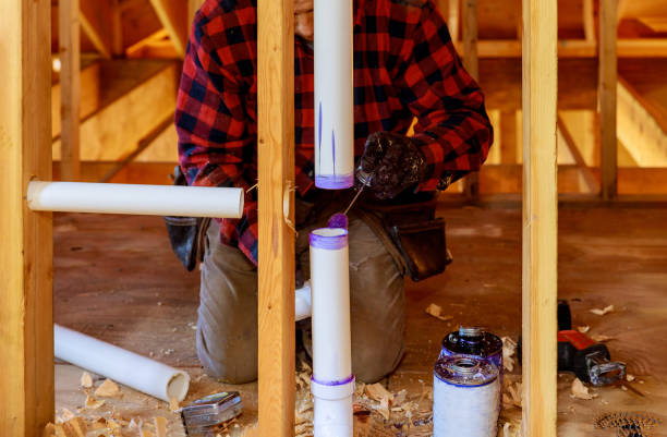istock A Plumber applying primer and glue a PVC pipe drain assembly 1172625819