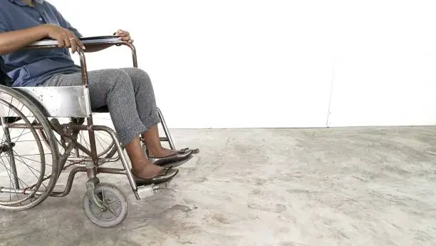 Woman sit on​ wheel chair.​ Empty​space​ wall​  background