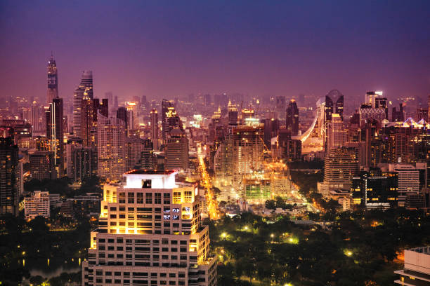 Downtown Bangkok illuminated aerial skyline view at blue hour Downtown Bangkok illuminated aerial skyline view at blue hour with a multitude of skyscrapers. taken on mobile device stock pictures, royalty-free photos & images