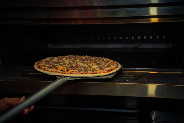 istock Close up chef making take pizza to oven at pizzeria restaurant kitchen. 1172639095
