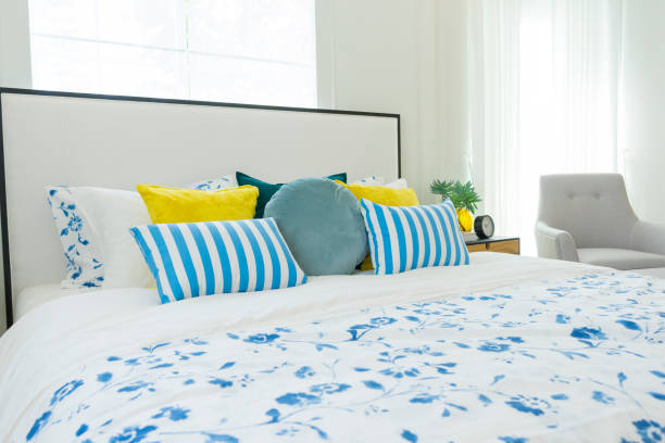 istock Yellow and blue pillows on white bed at home 1172642817