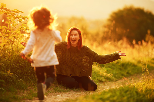 Little girl running in nature to her mother, mother is excited and impatient