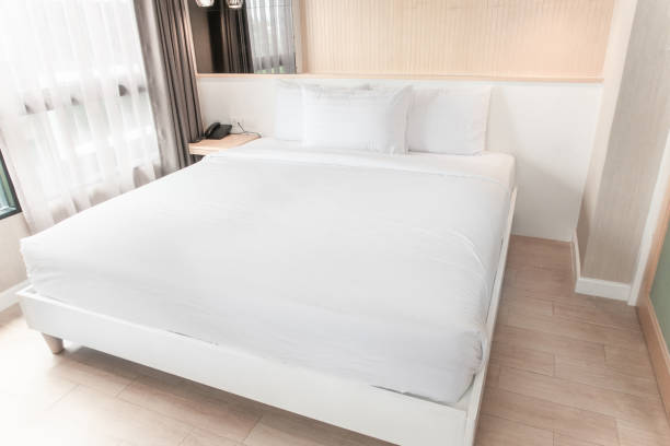 la cama doble blanca está decorada en madera y en tonos pastel. - sheet single bed bed duvet fotografías e imágenes de stock