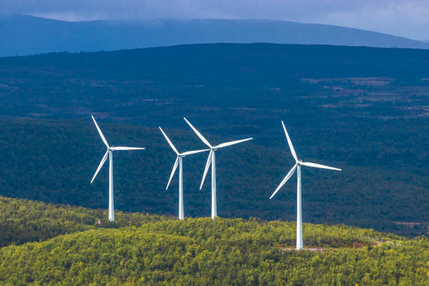 Four white wind turbines on Arctic mountain range with dark background Four white wind turbines in sunshine on Arctic mountain range in Swedish Lapland with dark background norrbotten province stock pictures, royalty-free photos & images