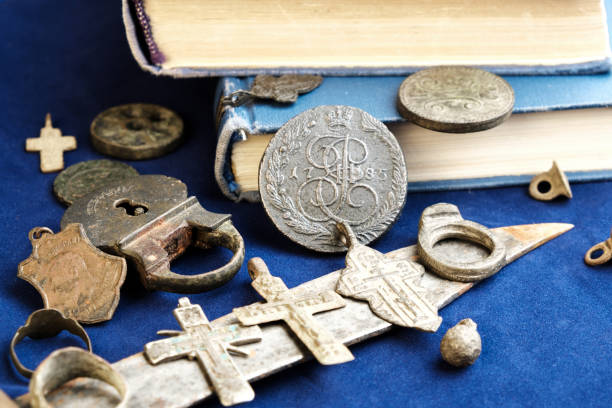 istock on a blue cloth background, ancient 19th-century coins, a rusty knife and personal items of people who lived long ago 1172646165