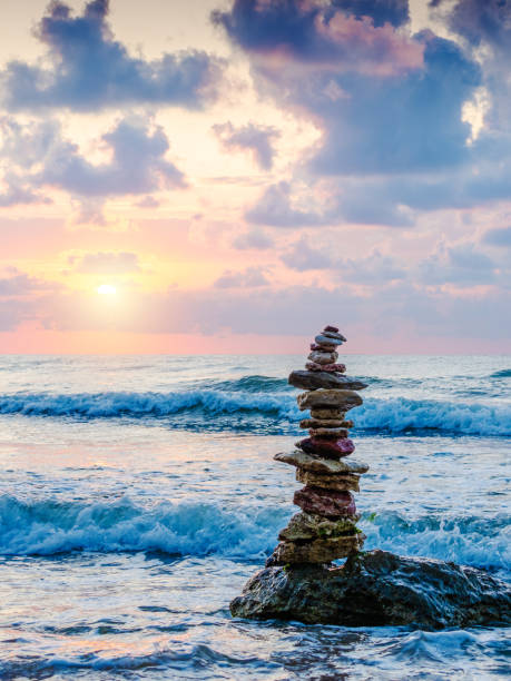 istock Stack of pebbles on beach with sun and beautiful sky on background 1172646726