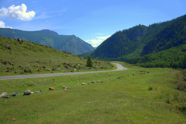 istock Asphalt road running through a mountain field valley. 1172650330