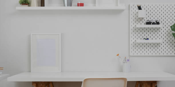 istock Minimal white workplace with mock up frame  and office supplies on white table 1172661133