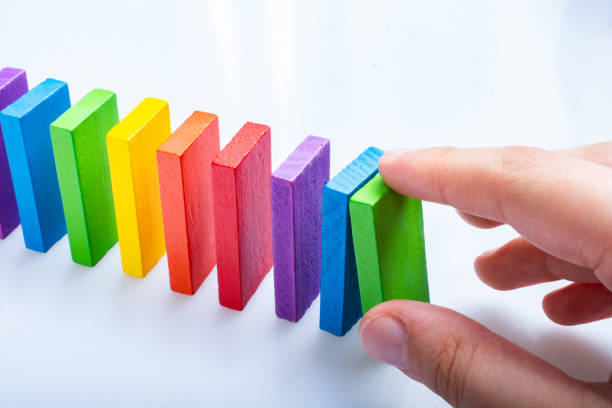 istock Hand playing with colorful domino blocks on white background 1172664016