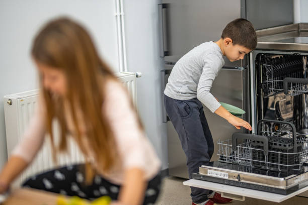 istock Boy placing plates in dishwasher 1172664383