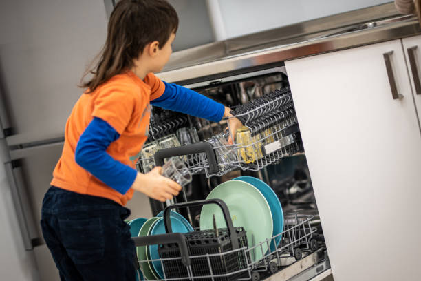 istock Boy placing glasses in dishwasher 1172664409