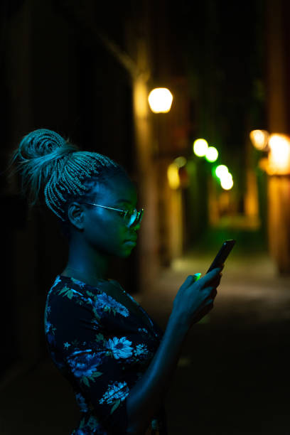 istock Cool young woman using smartphone at night 1172666934