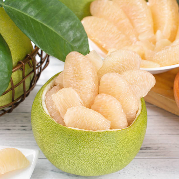istock Fresh peeled pomelo, grapefruit, shaddock on bright wooden table background. Seasonal fruit for Mid-Autumn Festival, close up, copy space. 1172667241