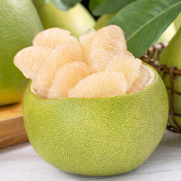 istock Fresh peeled pomelo, grapefruit, shaddock on bright wooden table background. Seasonal fruit for Mid-Autumn Festival, close up, copy space. 1172667244